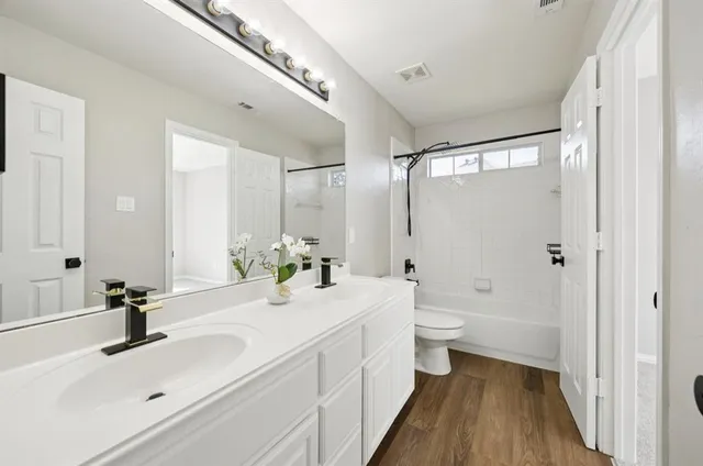 a bathroom with a double vanity sink toilet and shower