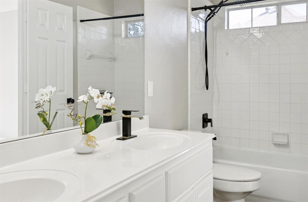 7913 Morningdew Drive Plano, TX 75025 - Photo 32 of 40 a bathroom with a sink a toilet and shower