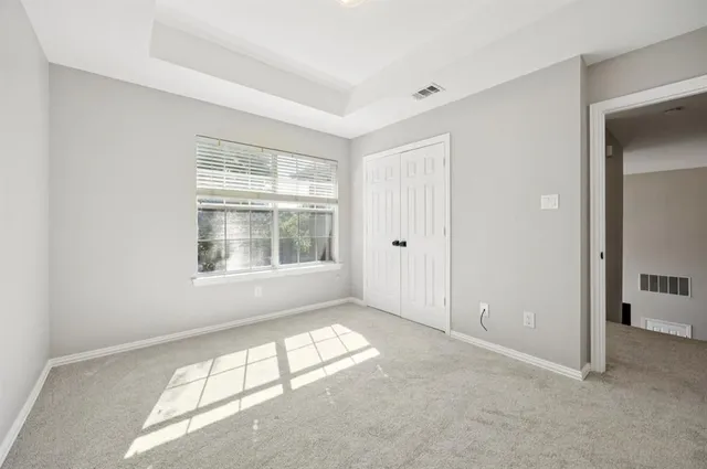 an empty room with windows and closet