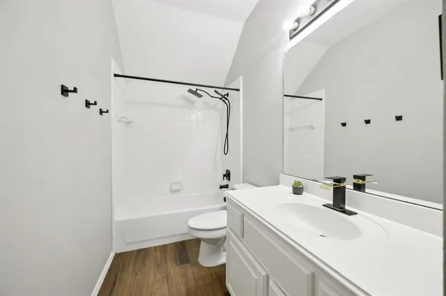 a bathroom with a sink a toilet and a large mirror