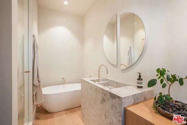 a bedroom with a bed and glass walk in closet