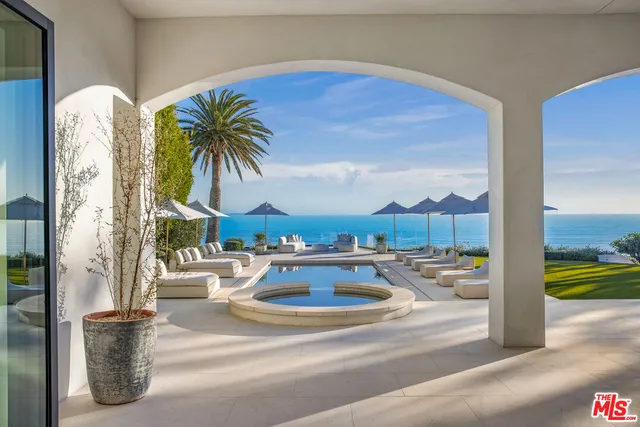 a front view of a house with swimming pool and sitting area