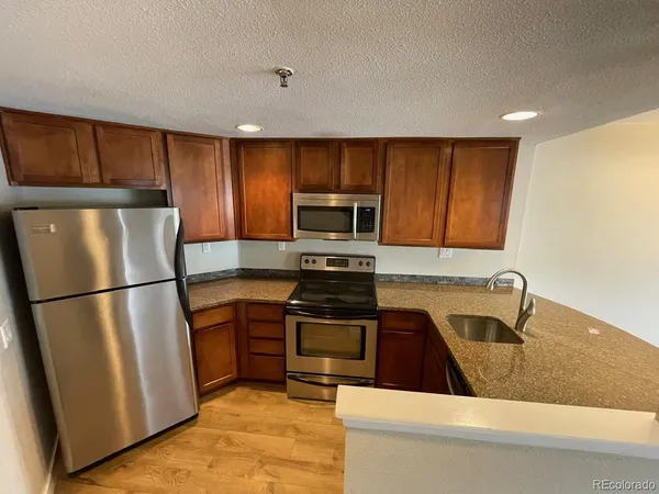 a kitchen with a refrigerator a stove top oven a sink and dishwasher