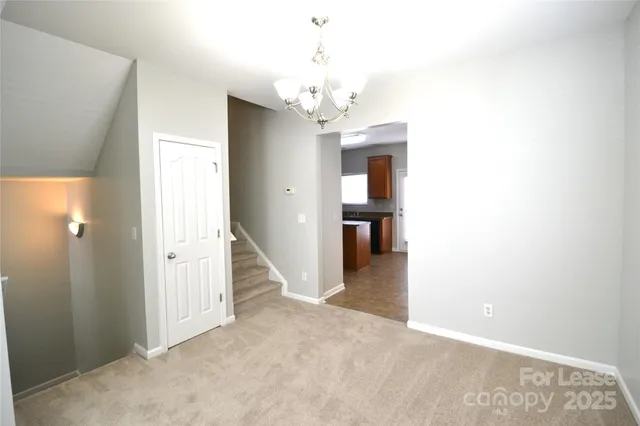 a view of a hallway with wooden floor and a chandelier