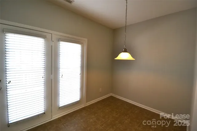 an empty room with a ceiling fan and a window