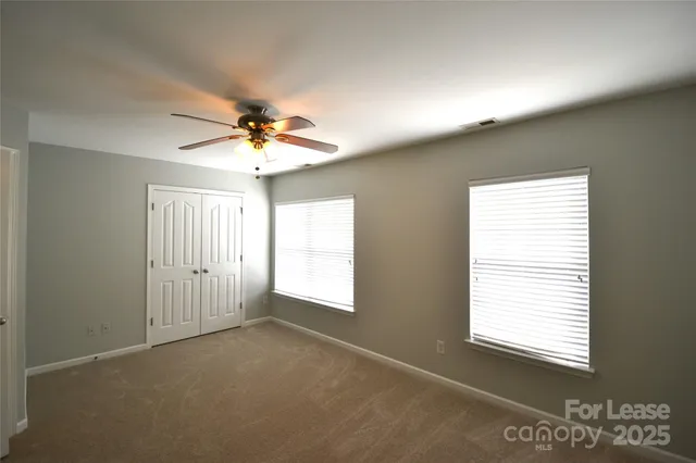 an empty room with a ceiling fan and a window