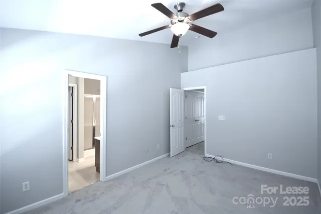 a view of room with ceiling fan and windows