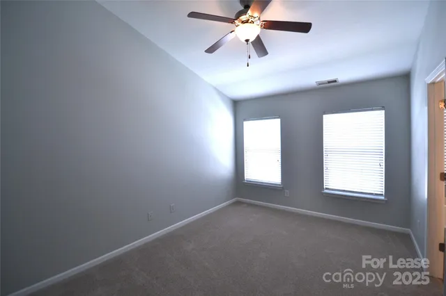 an empty room with a fan and a fan