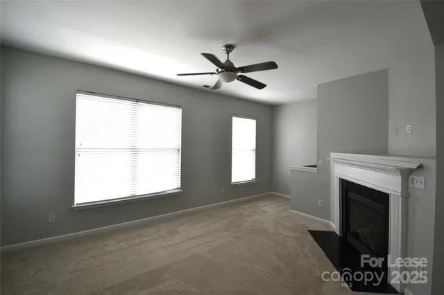 a view of empty room with fan and windows