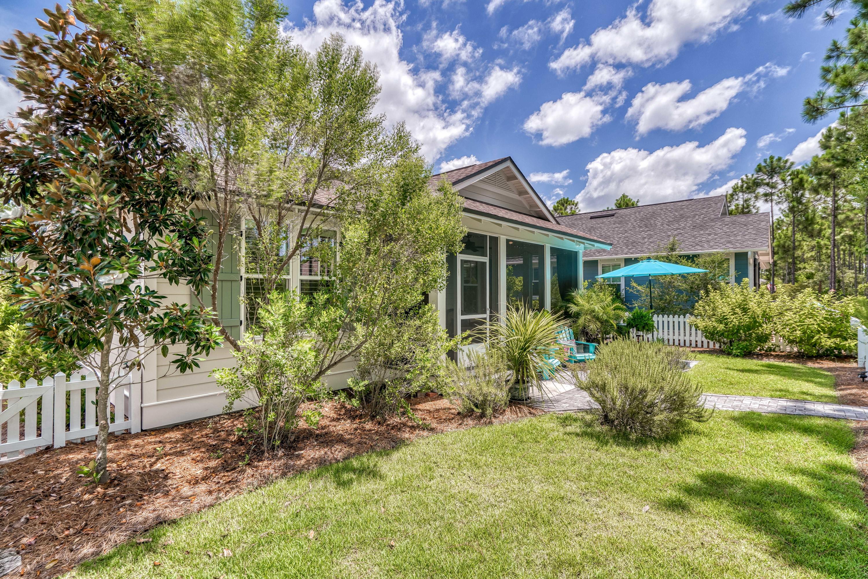 137 Jack Knife Drive Inlet Beach, FL 32461 - Photo 8 of 45 a yellow house with flower garden in front of it