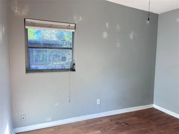 an empty room with wooden floor and a window