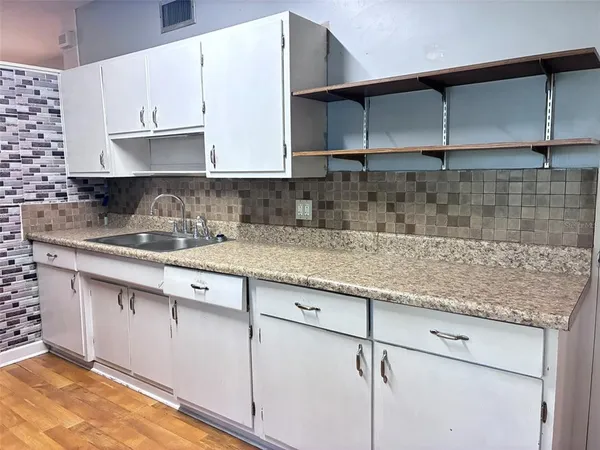 a kitchen with granite countertop a sink and cabinets