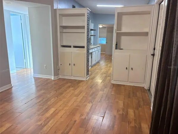 a view of empty room with wooden floor