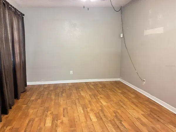 a view of an empty room with wooden floor