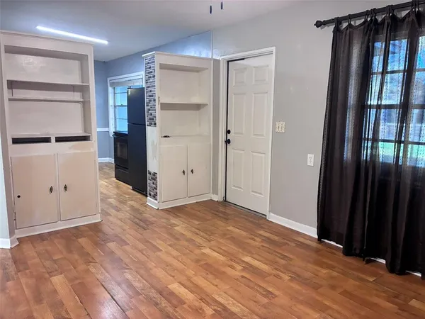 a view of an empty room with closet and a window