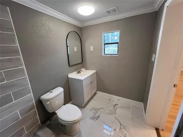 a bathroom with a toilet and a mirror