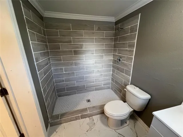 a bathroom with a toilet and a shower