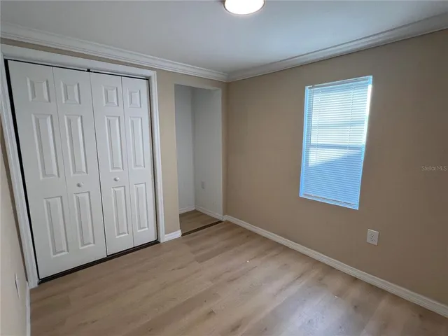 a view of an empty room with wooden floor