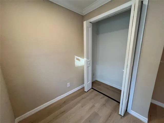 an empty room with wooden floor and closet