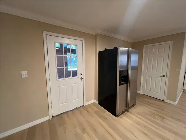 a view of kitchen with stainless steel appliances wooden floor and cabinets