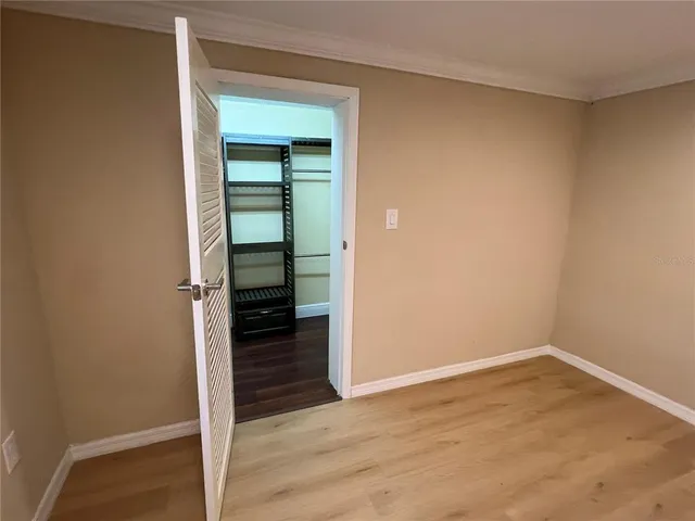 a view of a hallway with wooden floor and closet