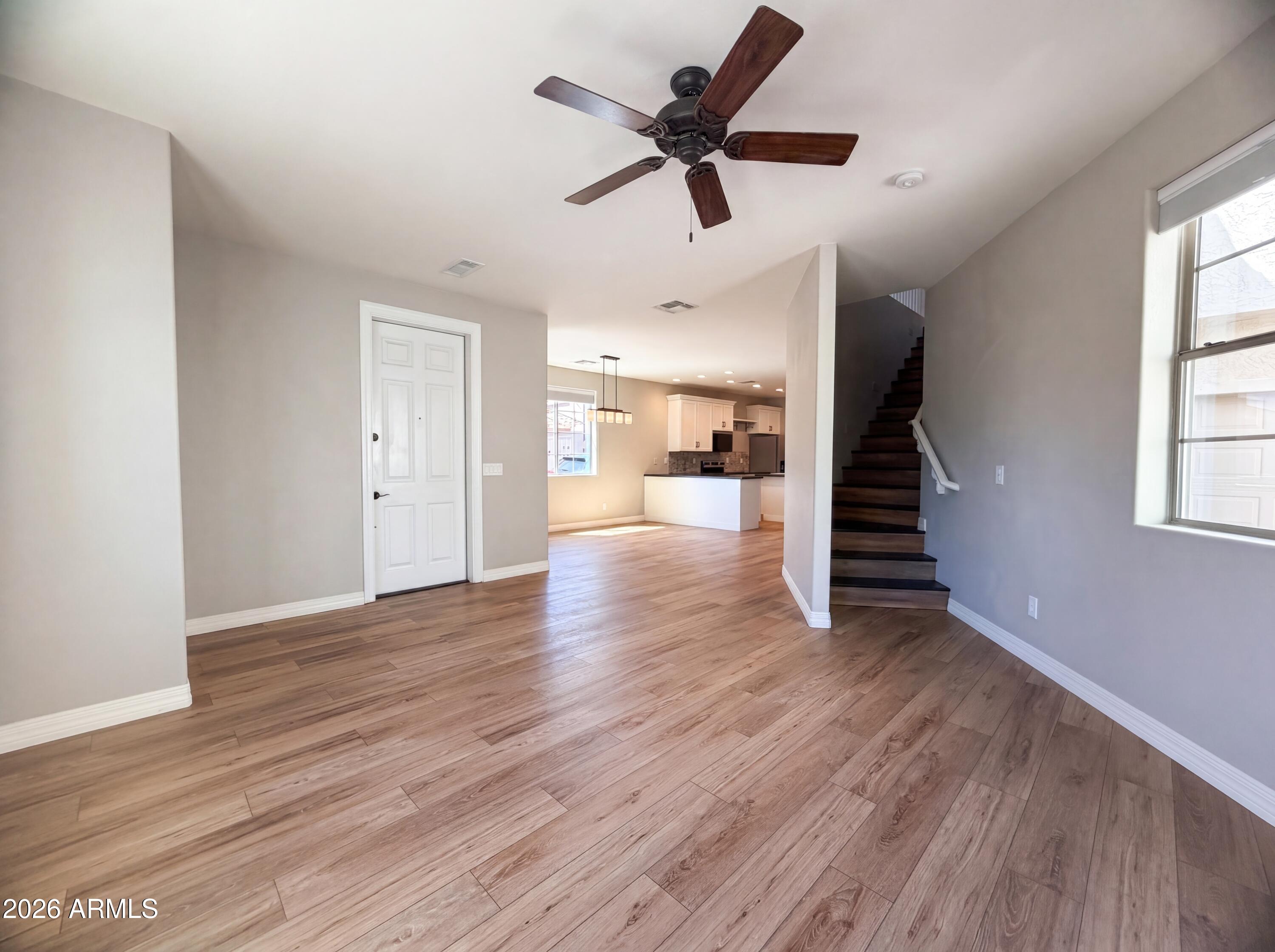 1729 South Desert View Place Apache Junction, AZ 85120 - Photo 3 of 17 a view of an empty room with wooden floor and a window