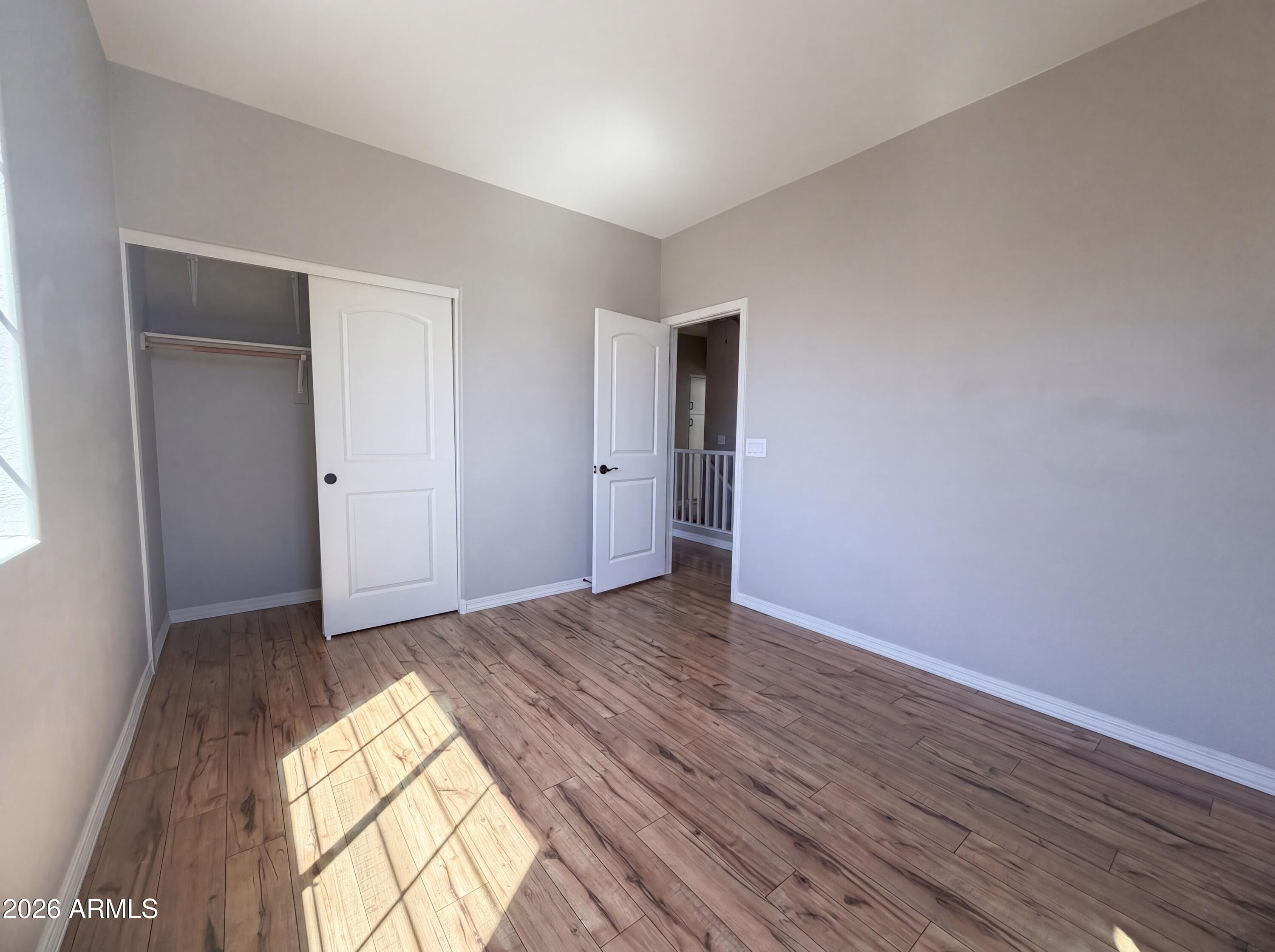1729 South Desert View Place Apache Junction, AZ 85120 - Photo 4 of 17 an empty room with wooden floor and natural light