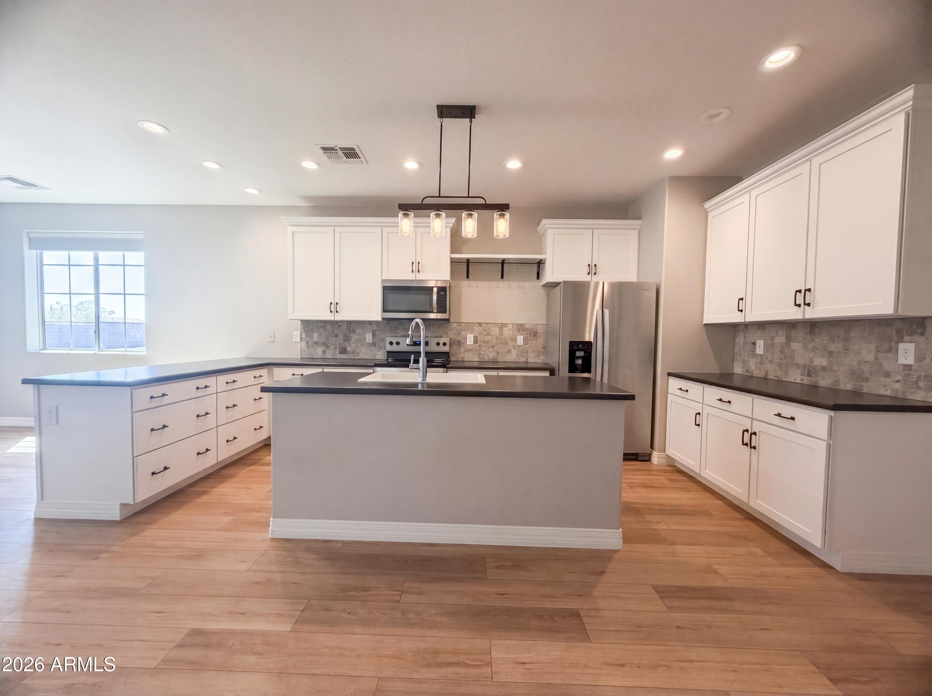 1729 South Desert View Place Apache Junction, AZ 85120 - Photo 7 of 17 a kitchen with kitchen island granite countertop a sink cabinets and stainless steel appliances