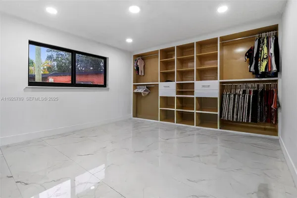 a view of an empty room with wooden floor and a cabinet
