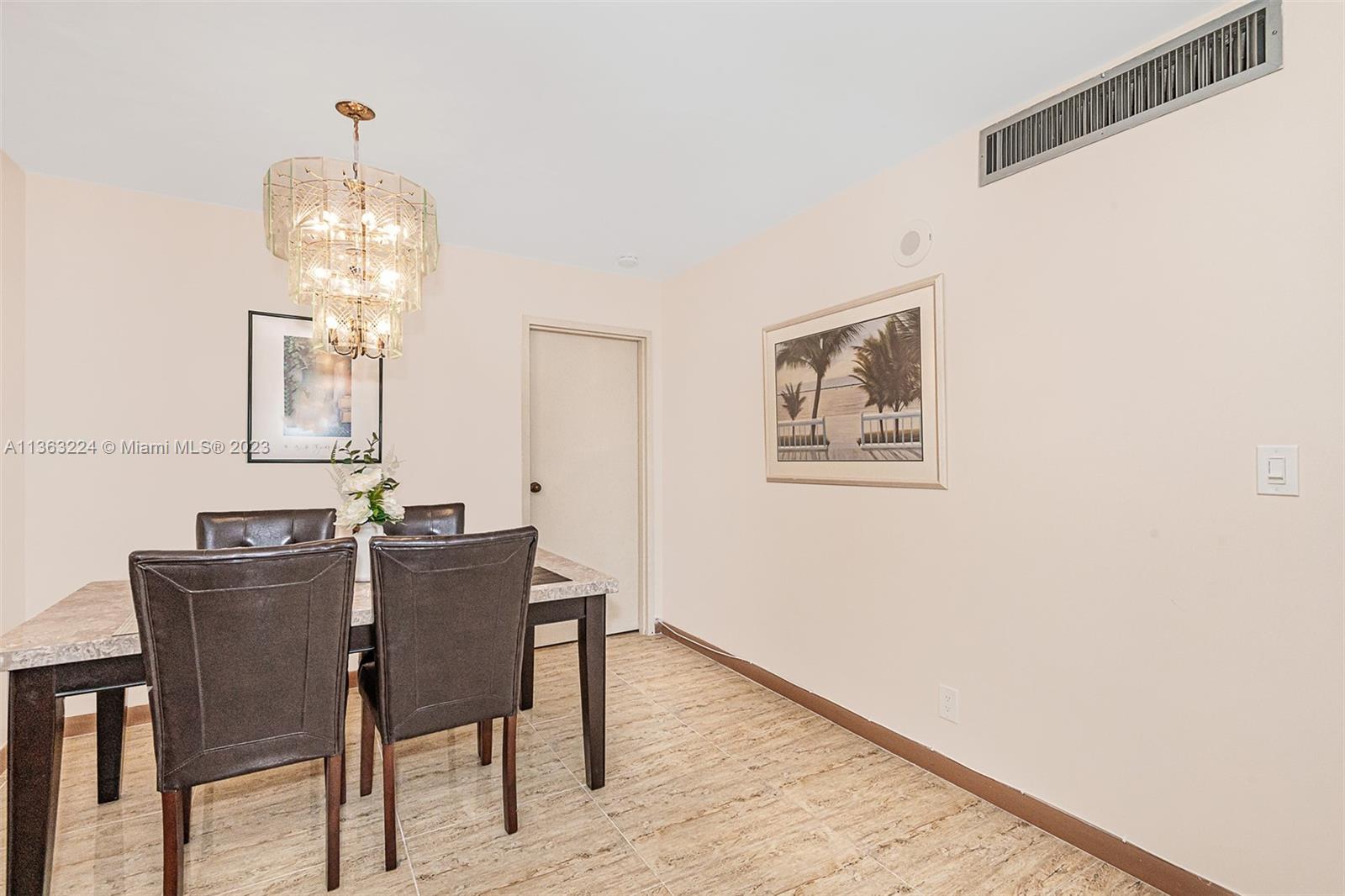 17011 North Bay Road, Unit 107 Sunny Isles Beach, FL 33160 - Photo 13 of 26 a view of a dining room with furniture and wooden floor