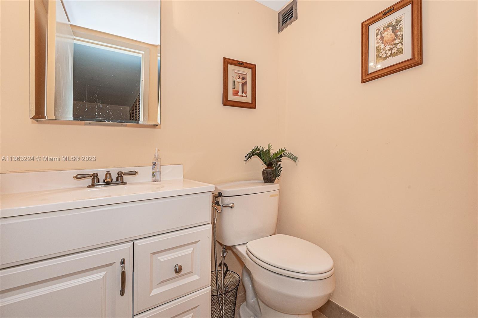 17011 North Bay Road, Unit 107 Sunny Isles Beach, FL 33160 - Photo 17 of 26 a bathroom with a toilet sink and mirror