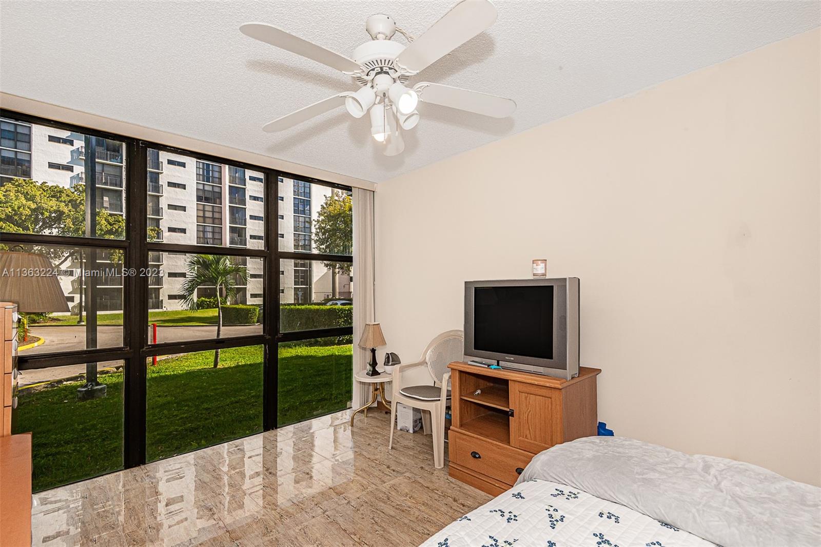 17011 North Bay Road, Unit 107 Sunny Isles Beach, FL 33160 - Photo 23 of 26 a living room with a flat screen tv and a floor to ceiling window