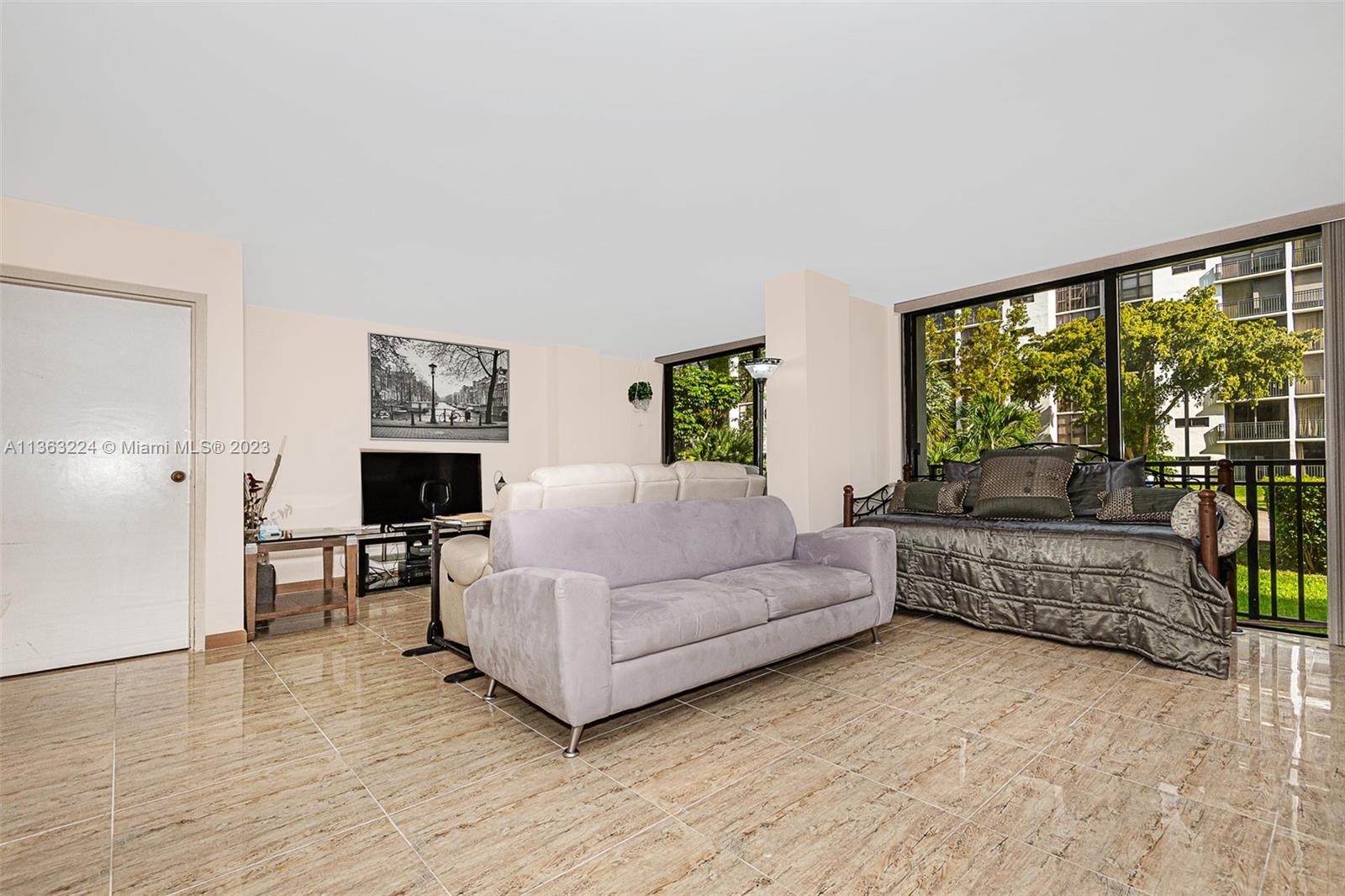 17011 North Bay Road, Unit 107 Sunny Isles Beach, FL 33160 - Photo 3 of 26 a living room with furniture and a fireplace