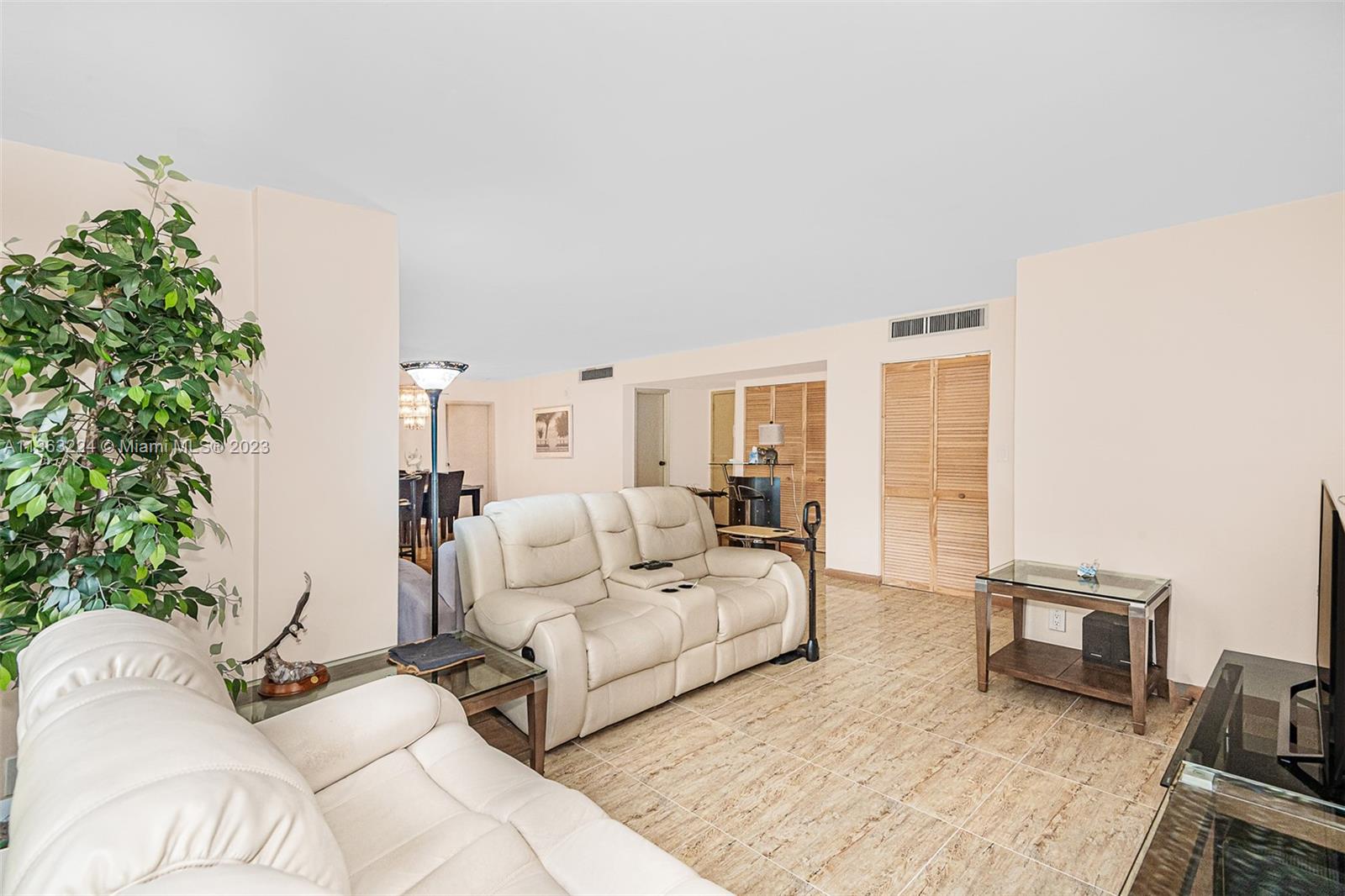 17011 North Bay Road, Unit 107 Sunny Isles Beach, FL 33160 - Photo 5 of 26 a living room with furniture and a potted plant