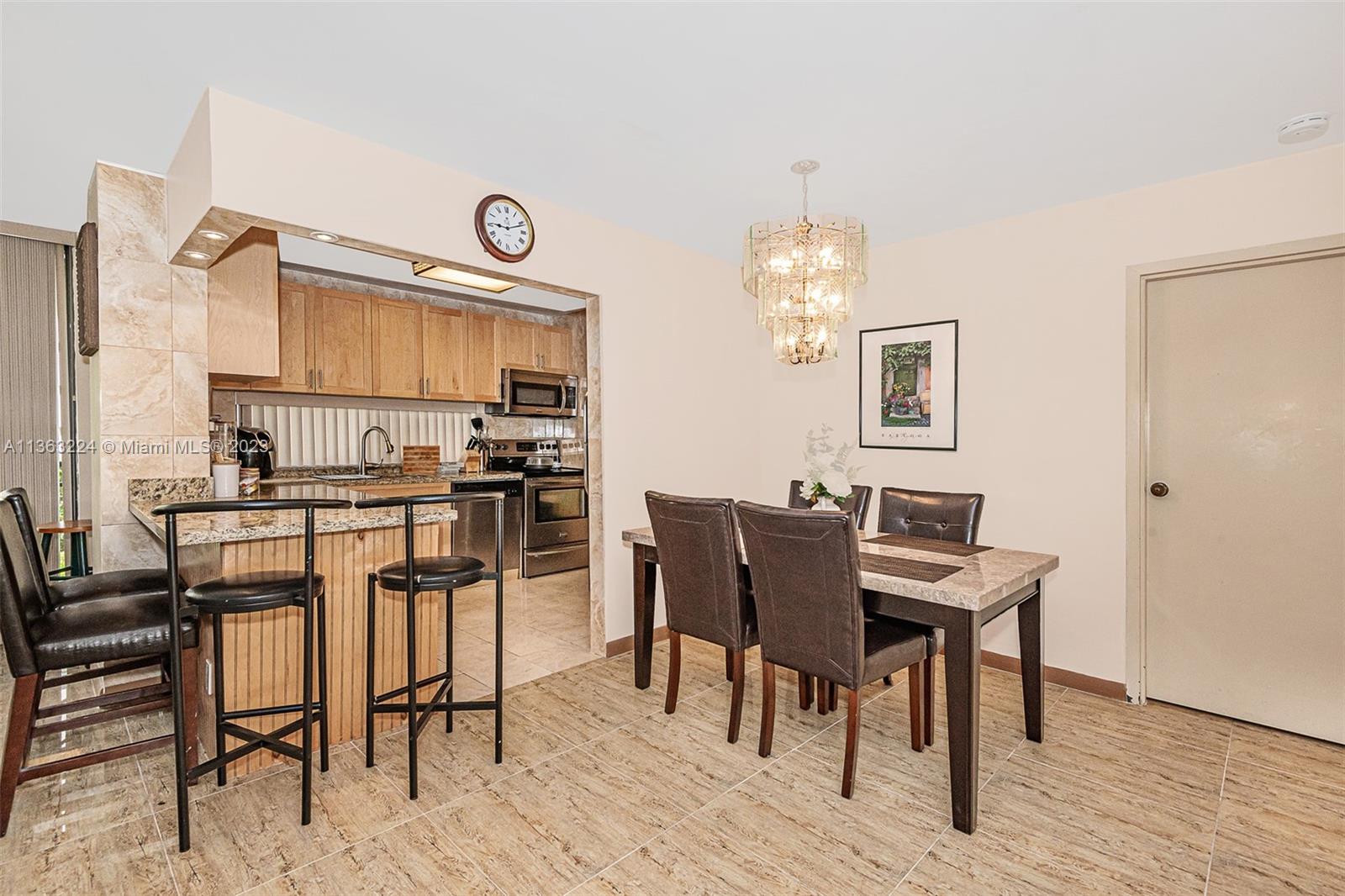 17011 North Bay Road, Unit 107 Sunny Isles Beach, FL 33160 - Photo 10 of 26 a view of a dining room with furniture and chandelier