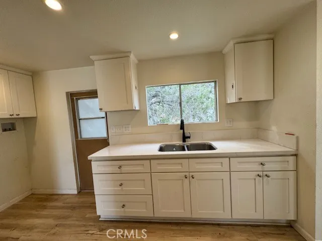 a kitchen with white cabinets and sink