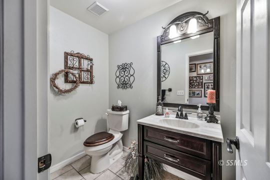 1213 Andrea Court Ridgecrest, CA 93555 - Photo 24 of 50 a bathroom with a toilet a sink and mirror