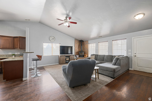 348 North Lodge Road Central, UT 84722 - Photo 18 of 25 Living area with dark wood finished floors, ceiling fan, a wood stove, and vaulted ceiling