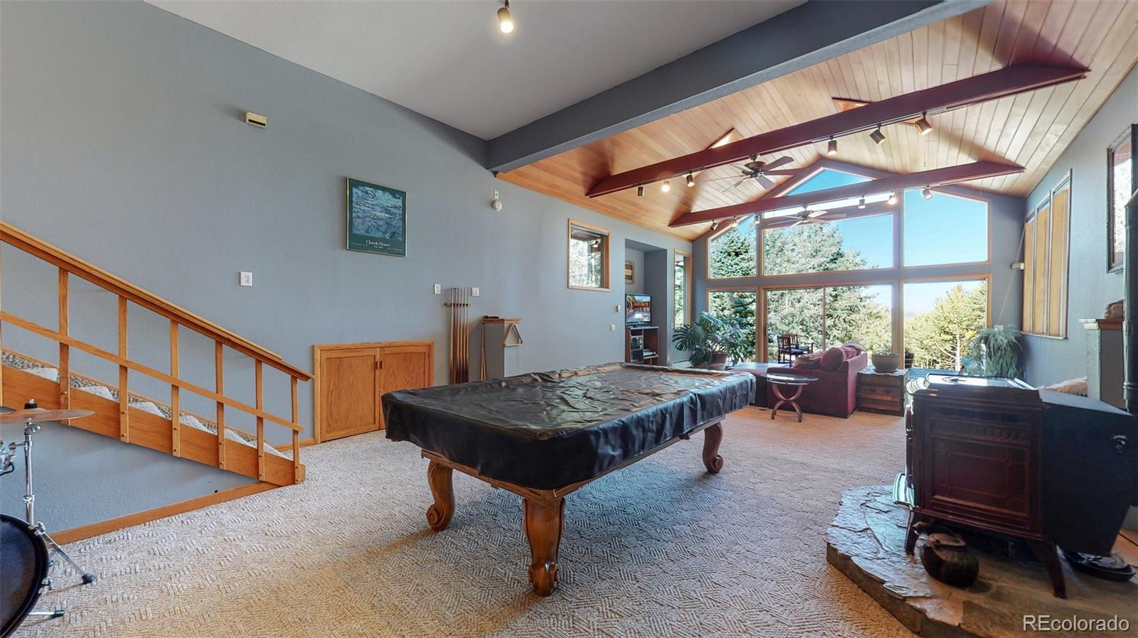 2720 South Spring Gulch Road Idaho Springs, CO 80452 - Photo 11 of 38 a living room with furniture a flat screen tv and a floor to ceiling window