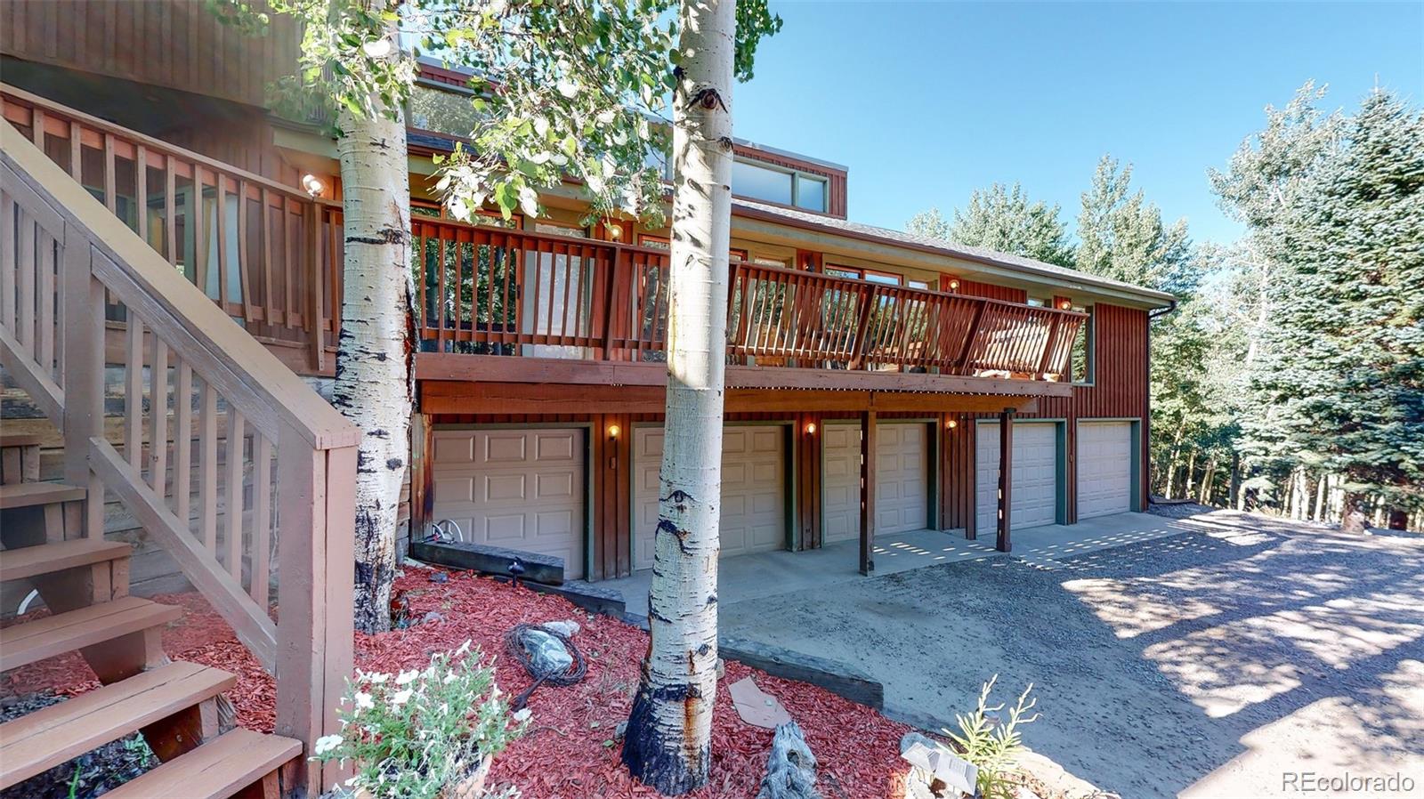 2720 South Spring Gulch Road Idaho Springs, CO 80452 - Photo 30 of 38 a view of a house with wooden stairs and a tree