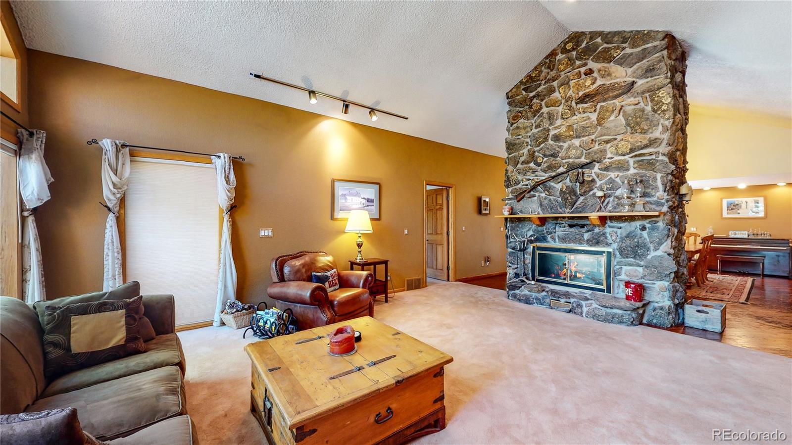 2720 South Spring Gulch Road Idaho Springs, CO 80452 - Photo 3 of 38 a living room with furniture and a fireplace