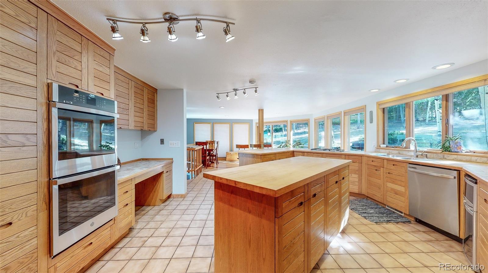 2720 South Spring Gulch Road Idaho Springs, CO 80452 - Photo 8 of 38 a large kitchen with kitchen island a sink a counter space and stainless steel appliances