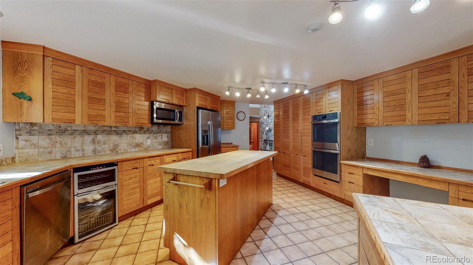 2720 South Spring Gulch Road Idaho Springs, CO 80452 - Photo 9 of 38 a kitchen with stainless steel appliances granite countertop a sink stove and refrigerator