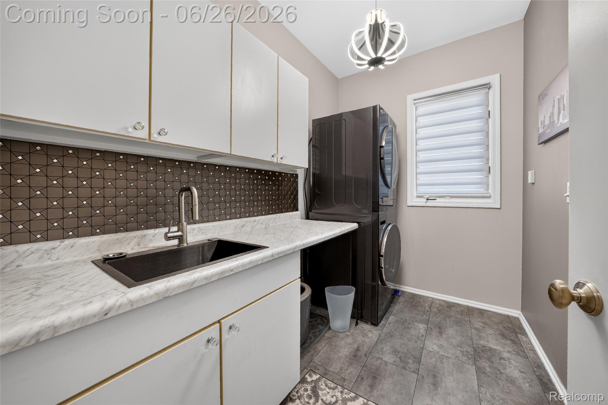 2619 Lambeth Park Rochester, MI 48306 - Photo 31 of 71 Laundry area featuring white cabinetry, a dark patterned tile backsplash, a utility sink with a brushed nickel faucet, light-toned countertops, and wood-finish flooring