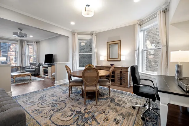 a living room with furniture a flat screen tv and large windows