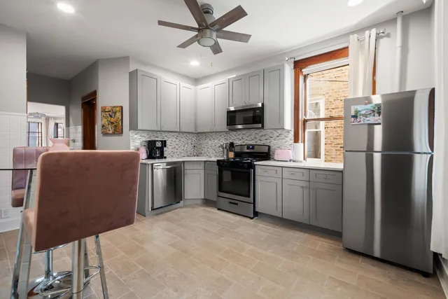 a kitchen with stainless steel appliances granite countertop a refrigerator a stove a sink a oven and a refrigerator