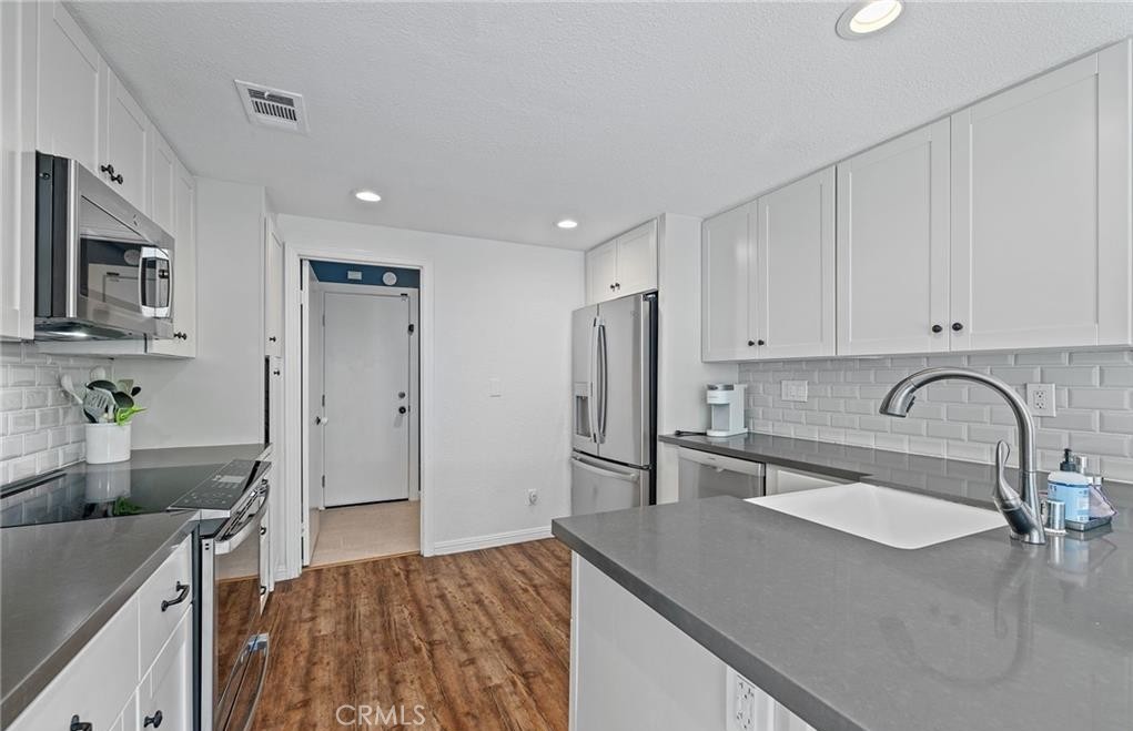 164 Stanford Court, Unit 82 Irvine, CA 92612 - Photo 11 of 34 a kitchen with stainless steel appliances granite countertop a sink a stove and a refrigerator