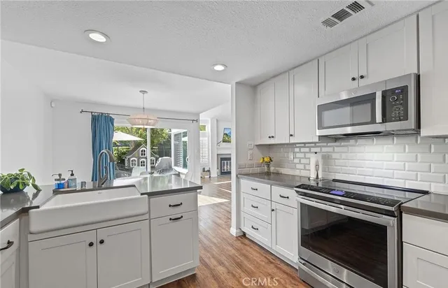 a kitchen with stainless steel appliances white cabinets and a stove top oven