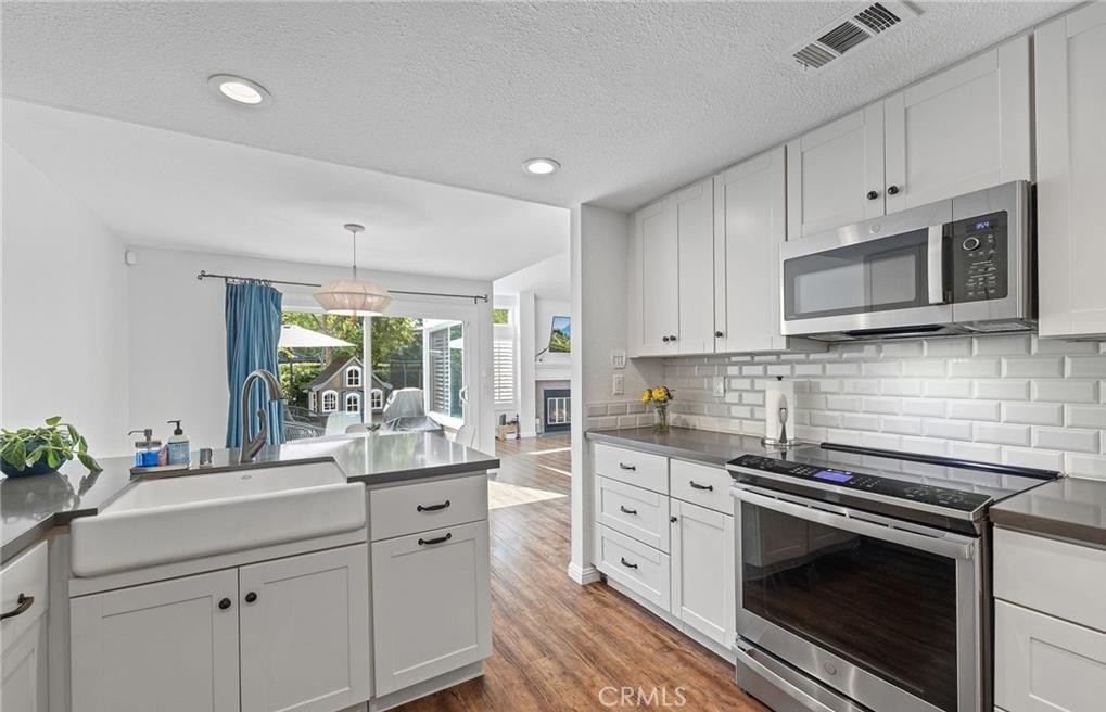 164 Stanford Court, Unit 82 Irvine, CA 92612 - Photo 12 of 34 a kitchen with stainless steel appliances white cabinets and a stove top oven