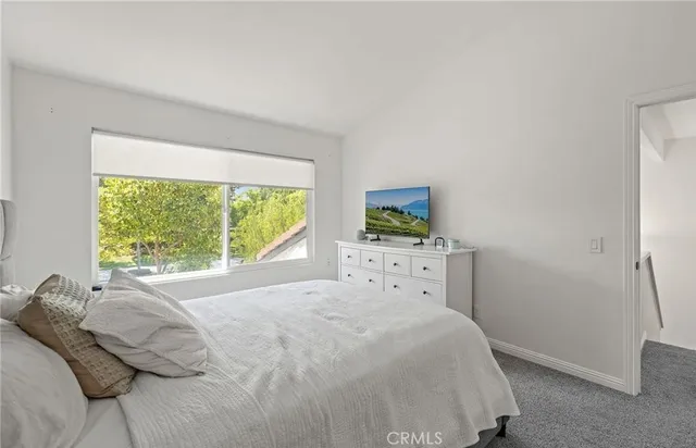 a bedroom with a bed and large window